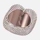 Heart-shaped mirror with rose gold frame and gemstone accents on a light pink background